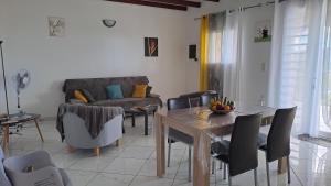 a living room with a table and a couch at Villa les Alizés in Les Anses-dʼArlets