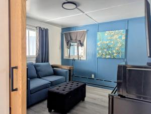 a blue living room with a couch and a tv at Scotty's Motel in Munising