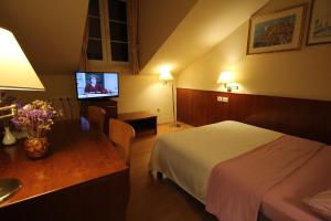 
a hotel room with a bed, tv and a desk at Villa Koruna - Mali Ston in Ston
