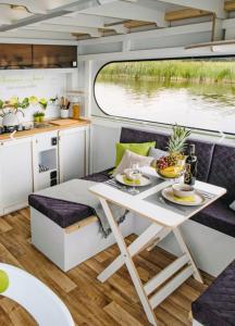 a kitchen and dining area in an rv with a table at Neues Hausboot für 4 Personen Müritz und Plauer See in Lübz