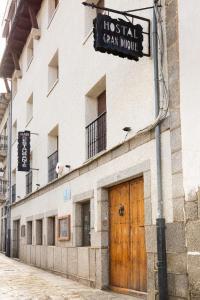 a building with a wooden door and a sign on it at Hostal Gran Duque in Piedrahita