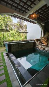 a swimming pool in a house with an archway at Baruna Sari Villa yoga and reatret view jungle in Ubud