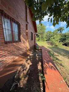 a brick building with a sidewalk in front of it at Cabañas la flor in Puerto Piray