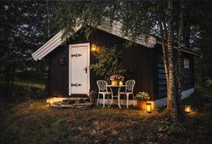 a table and two chairs in front of a cabin at Traditional timber farm with Sauna & Wi-Fi in Baukål