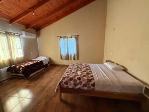 a bedroom with two beds in a room with wooden floors at Cabañas la flor in Puerto Piray