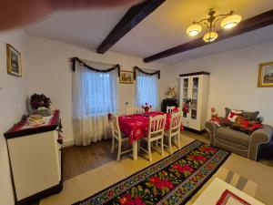 a living room with a table and chairs and a couch at Balada Copilăriei Ciprian Porumbescu in Ciprian Porumbescu