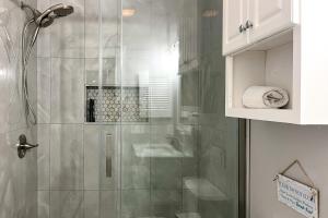 a shower with a glass door in a bathroom at Myrtle Beach Condo: Golf Course + Pool View! in Myrtle Beach +18 photos