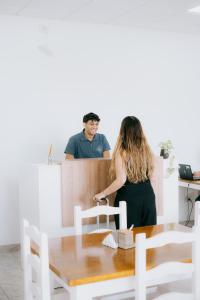 a woman standing at a counter with a man at Río Hotel in Colorado River