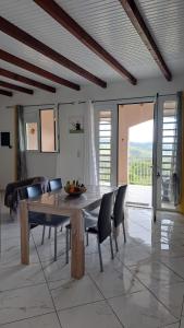 a dining room with a wooden table and chairs at Villa les Alizés in Les Anses-dʼArlets