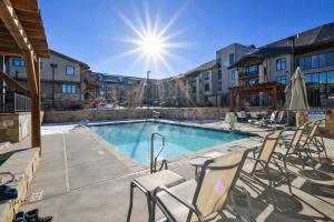 a pool at a hotel with chairs and the sun at Tranquil Blackstone Getaway in Park City