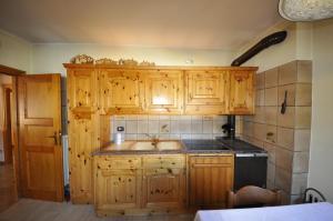 a kitchen with wooden cabinets and a sink at P&P Home in Valdidentro