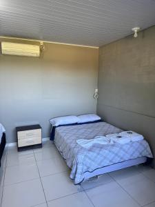 a bedroom with a bed and a night stand at Pousada Bonetti Quarto 1 in Santa Rosa