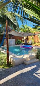 a swimming pool with a hammock and a palm tree at Casa OM in El Cuyo