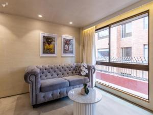 a living room with a couch and a large window at Palace by Wynwood House in Bogotá