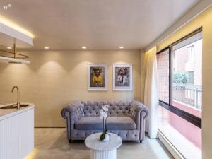a living room with a couch and a large window at Palace by Wynwood House in Bogotá