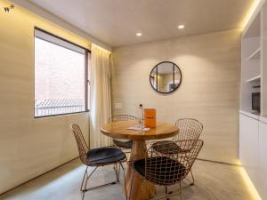 a dining room with a table and chairs and a mirror at Palace by Wynwood House in Bogotá