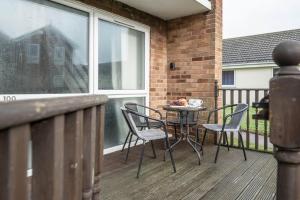 a patio with a table and chairs on a balcony at 100 Waterside Park in Corton +22 photos