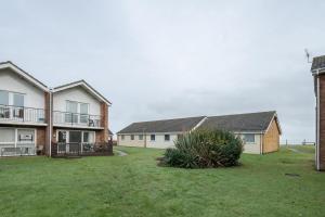 a group of houses with a grass yard at 100 Waterside Park in Corton