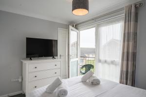 a bedroom with a bed with a tv and a window at 100 Waterside Park in Corton