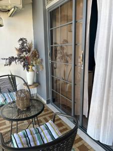 a patio with two chairs and a table and a glass door at Cayenne Centre Eco Castor in Cayenne