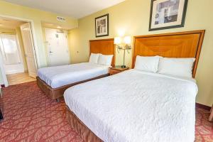 a hotel room with two beds with white sheets at Oceanfront Convenience on Lower Floor, Heated Pool in Myrtle Beach