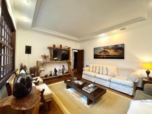 a living room with a couch and a table at Fazenda Vale Dourado in Nova Friburgo
