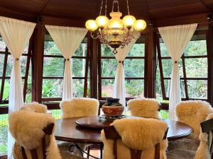 a dining room with a table and chairs and a chandelier at Fazenda Vale Dourado in Nova Friburgo