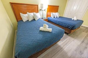 two beds in a hotel room with towels on them at 2BR Pools, Direct Oceanfront Views, Handicap, Nice in Myrtle Beach