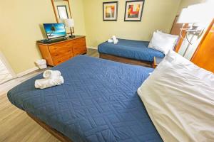 two beds in a hotel room with towels on them at 2BR Pools, Direct Oceanfront Views, Handicap, Nice in Myrtle Beach +46 photos