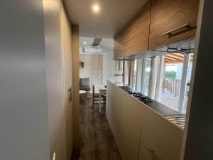 a kitchen with white cabinets and a counter top at La Carabasse camping siblu in Vias
