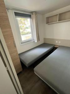 a small room with a bed and a window at La Carabasse camping siblu in Vias