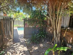 a gate to a yard with a tree and a fence at CLR-Accommodation in George