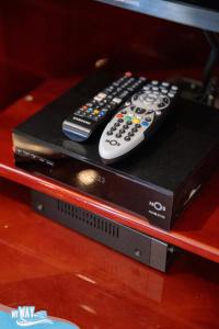 two remote controls sitting on top of a video game system at Barco no Coração da Cidade - Iate de 5 estrelas in Viana do Castelo