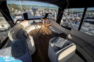 a boat with chairs and a table on the deck at Barco no Coração da Cidade - Iate de 5 estrelas in Viana do Castelo