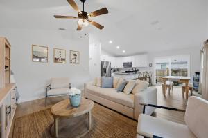 a living room with a white couch and a ceiling fan at Cozy Coastal Cottage Minutes to Beach and Downtown in St. Augustine