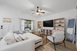 a living room with a white couch and a flat screen tv at Cozy Coastal Cottage Minutes to Beach and Downtown in St. Augustine