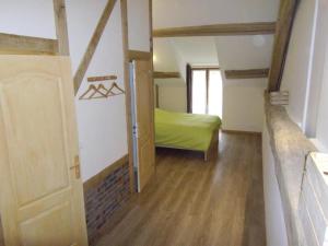 a small room with a green bed and a door at Les puisayennes in Treigny