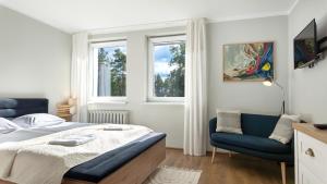 ein Schlafzimmer mit einem Bett und einem blauen Stuhl in der Unterkunft Krechowiak in Augustów + 93 Fotos