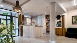 eine Lobby mit einer Säule und einem Bücherregal in der Unterkunft Krechowiak in Augustów
