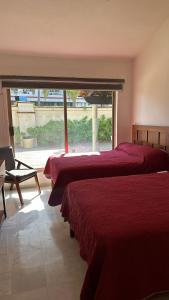 a bedroom with two beds and a large window at Villa 1 en Hotel Tesoro Ixtapa in Ixtapa