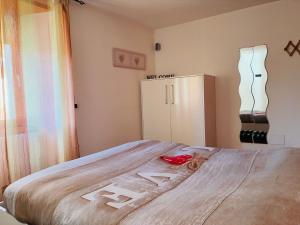 a bedroom with a bed with the letters ra on it at Casa Vacanza l' antico molino in Grosotto