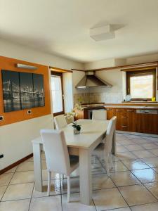 a kitchen with a dining room table and white chairs at Casa Vacanza l' antico molino in Grosotto