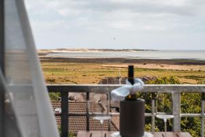 a view of the beach from a balcony at Hotel Hüttmann in Norddorf