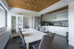 a kitchen and dining room with a white table and chairs at Cabanele CARMEL in Muntele Rece
