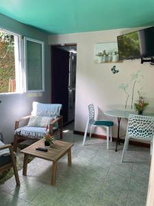 a living room with a couch and a table at LES JOYAUX DE BALATA in Saint-Joseph