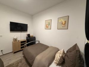 a bedroom with a bed and a flat screen tv at Gaststätte Seehaus Maroth in Maroth +10 photos