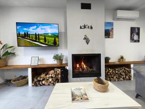a living room with a fireplace and a tv on the wall at Alojamiento Rural El Lentisco in Puente Honda