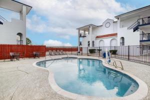 a swimming pool in front of a building at SureStay Hotel by Best Western Spring North Houston in Spring