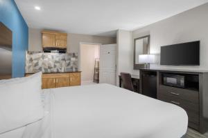 a hotel room with a bed and a kitchen at SureStay Hotel by Best Western Spring North Houston in Spring
