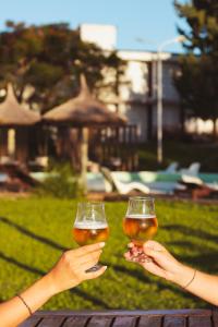 two people holding up glasses of beer at Tramonto hotel & ristorante in Empedrado +43 photos